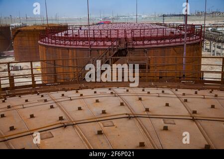 Rusted oil storage tanks on blue sky background. Asphaltic bitumen plant. Stock Photo