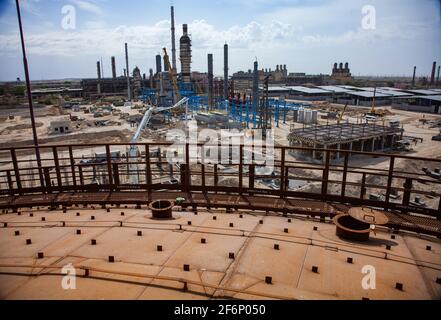 Rusted oil storage tanks on blue sky background. View from tank's roof. Asphaltic bitumen plant. Stock Photo