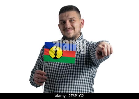 White guy holding a flag of New Caledonia and points forward in front of him isolated on a white background. Stock Photo