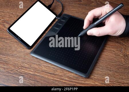 Professional designer using graphic tablet connected to smartphone with digital pen. Close up retouching photo. Computer drawing by stylus. Making mod Stock Photo