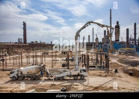 Aktau, Kazakhstan - May 19, 2012 Construction of modern asphaltic bitumen plant. Making reinforcement building columns. Concrete pump truck filling fo