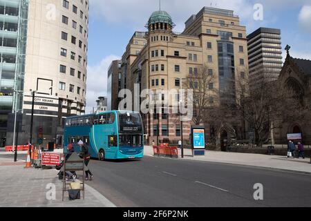 The Leeds City Centre in the UK showing high rise office blocks in the area know as City Square with a bus driving to the bus stop Stock Photo