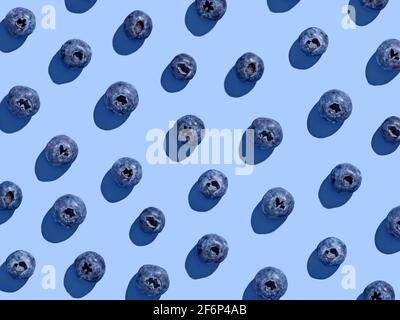 Colorful blueberry pattern on blue background, from above, hard shadow Stock Photo