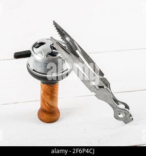 Brown ceramic hookah bowl with metal lid and tongs on a white wooden background. Stock Photo