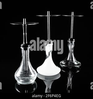 Three hookahs on a black mirror background. Stock Photo