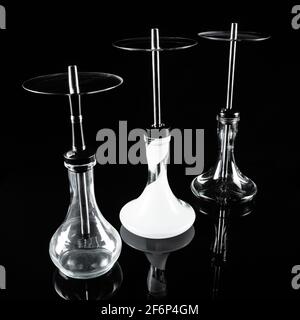Three hookahs on a black background with a reflection. Stock Photo