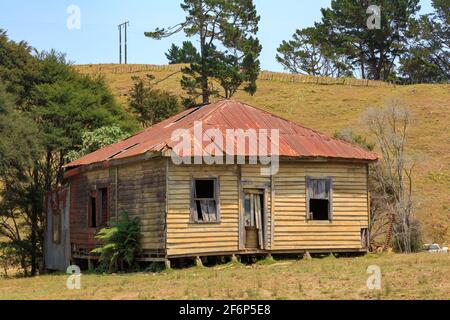A picturesque abandoned wooden and corrugated iron farmhouse on the Coromandel Peninsula, New Zealand