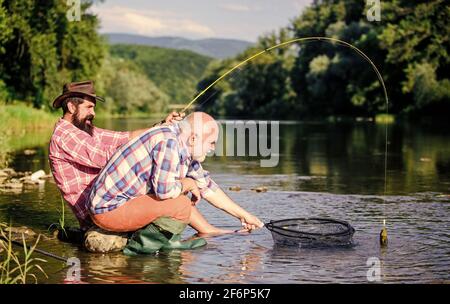 fly fish hobby of men. retirement fishery. Two male friends fishing together. big game fishing. relax on nature. happy fishermen friendship. retired Stock Photo