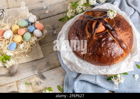 Portuguese traditional Easter cake. Folar with eggs on easter table. Colorful painted eggs. Stock Photo