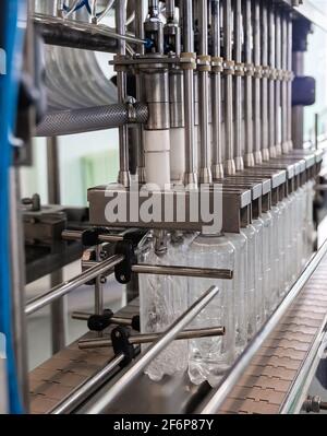 Filling of mineral water in plastic bottles. Water production line. Stock Photo