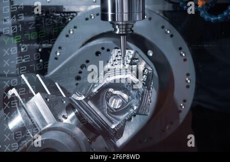 Modern industry high precision CNC milling machine cutting engine part. CNC programming code. Industrial metalworking manufacturing. Stock Photo