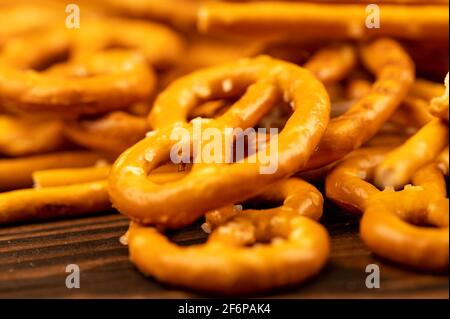 Salted breadsticks and salted pretzels scattered on the table. Close-up selective focus. Stock Photo