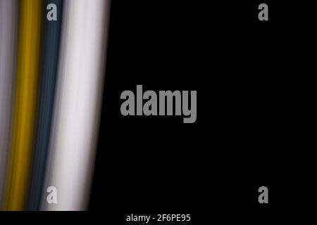black background with straight gray, yellow and white light lines to the left Stock Photo
