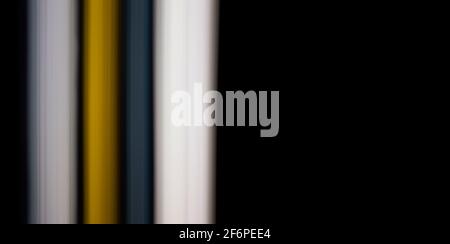 black background with straight gray, yellow and white light lines to the left Stock Photo