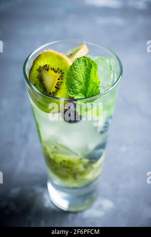 Fresh summer cocktail with blueberry and kiwi on the wooden background. Selective focus. Shallow depth of field. Stock Photo