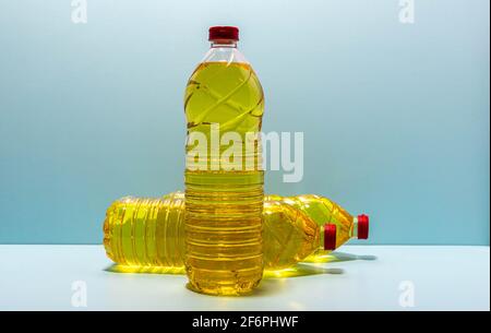 plastic bottles with edible soy oil on blue background. Vegetable oil. Soy oil is a type of vegetable oil extracted from soy beans and is rich in poly Stock Photo