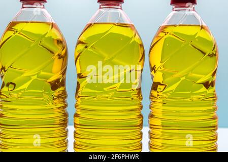 plastic bottles with edible soy oil on blue background. Vegetable oil. Soy oil is a type of vegetable oil extracted from soy beans and is rich in poly Stock Photo