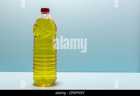 plastic bottles with edible soy oil on blue background. Vegetable oil. Soy oil is a type of vegetable oil extracted from soy beans and is rich in poly Stock Photo
