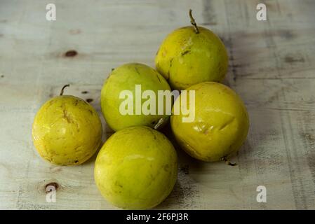 Yellow passion fruit (Passiflora edulis Sims) fruits on wooden construction background. Fruit produced by plants of the genus Passiflora. America's tr Stock Photo