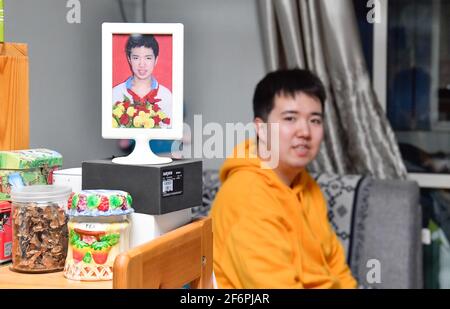 (210402) -- TIANJIN, April 2, 2021 (Xinhua) -- Photo shows Zhang Hao posing with a portrait of him when he graduated from a school for people with autism in Hebei District, north China's Tianjin, March 29, 2021.  In 1998, Zhang Hao was diagnosed with autism at the age of two. Ever since the diagnosis, Zhang's mother Wu Guixiang has spent all her time looking after her son.    In order to help Zhang Hao and eight others with autism improve their social engagement after they had become grown-ups, Wu set up an autism training center in 2016, providing them with courses on life, social and vocatio Stock Photo
