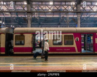 Mumbai, India - January 7, 2021 : Unidentified passengers (blurred faces) walking on a platform  at CST station, one of the busiest train station for Stock Photo