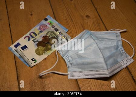 german euro bank notes on the floor with various items like a wallet, a mask or a treasurey chest Stock Photo