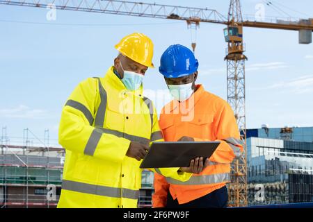 Construction Site Engineer And Building Inspection Looking At Tablet Stock Photo