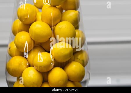 lemons in a glass vase on a white background Stock Photo