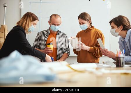 Two females making notes while woman cutting cloth Stock Photo