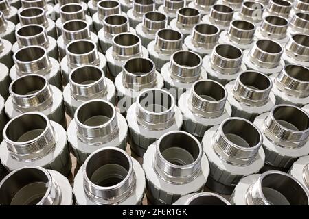 many metal pipe couplings in a pipe factory Stock Photo