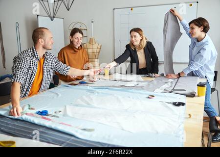 Male student passing triangle ruler to fashion teacher Stock Photo