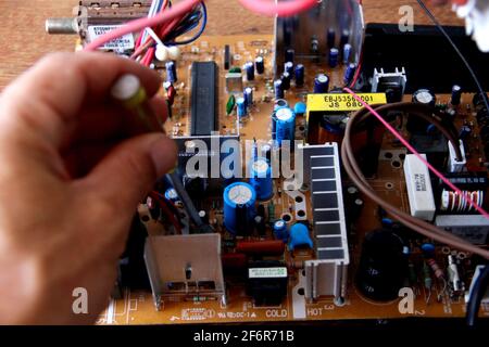 salvador, bahia / brazil - october 17, 2014: technician checking electronic television circuit board in the city of Salvador. *** Local Caption ***  . Stock Photo