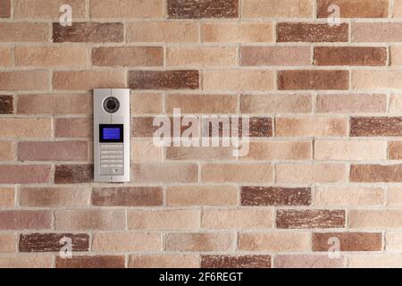 intercom with camera on brick wall, close up and copy space Stock Photo
