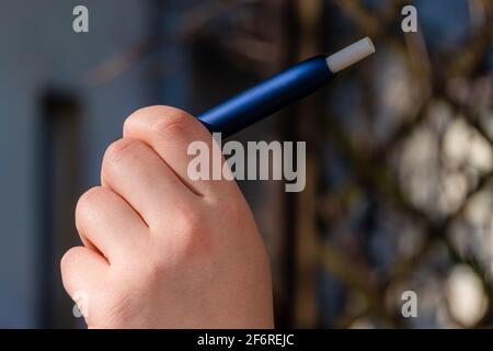 Woman holding e-cigarette. Close up of smoking electronic cigarette. Alternative nicotine heating product Stock Photo