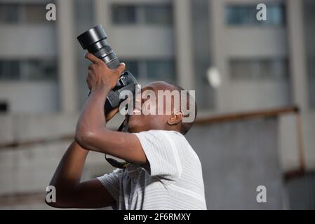 young man outdoors photographing something. Stock Photo