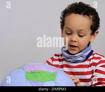 boy with globe looking up on white background stock photo Stock Photo