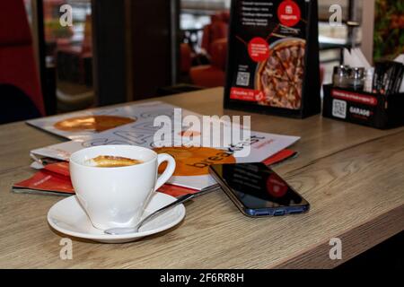 BELARUS, VITEBSK - SEPTEMBER 10, 2020: Cup of coffee and magazines on table Stock Photo