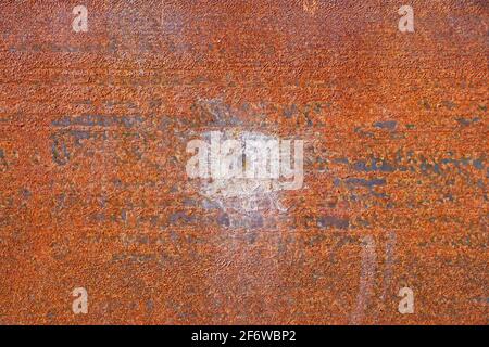 site of bullet impact on rusty iron plate Stock Photo