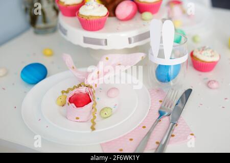 close up of easter egg wrapped in pink napkin shaped like bunny ears Stock Photo