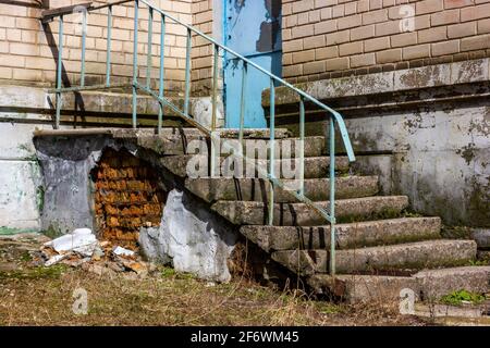 Emergency staircase in an abandoned place. Old concrete porch. Dangerous concrete steps. Stock Photo