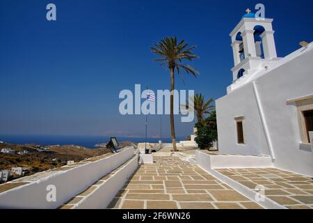 Beautiful whitewashed church next to palm trees in Ios cyclades Greece Stock Photo