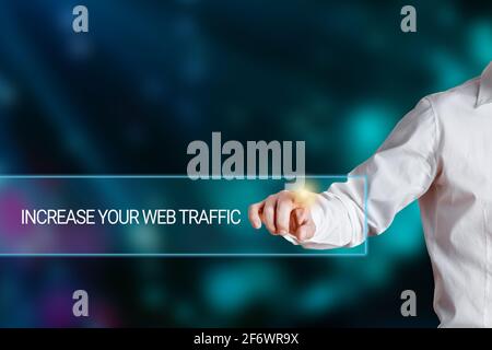 Male hand pressing the words increase your web traffic on a virtual search display bar. Website traffic boost concept. Stock Photo