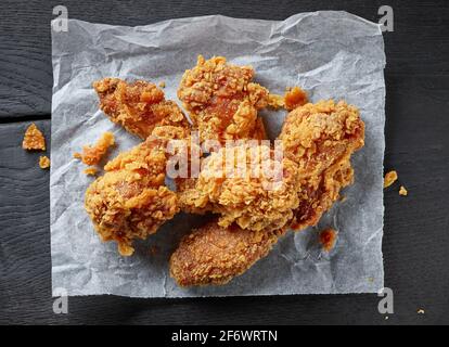portion of fried chicken wings on black wooden table, top view Stock Photo