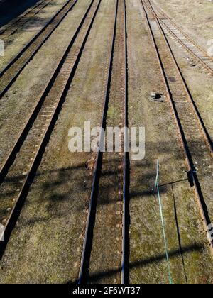 Drone shot over a railway sorting station with trains at sunset. Photo railway tracks, aerial top view. Stock Photo