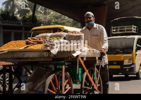 K.R.Market, Bangalore, India - February 06,2021: Muslim street seller on a vehicle during COVID-19 pandemic Stock Photo