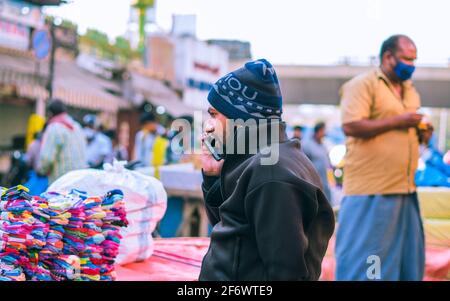 K.R.Market, Bangalore, India - February 06,2021: Street seller talking over a phone in K.R.Market Stock Photo