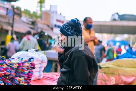 K.R.Market, Bangalore, India - February 06,2021: Street seller talking over a phone in K.R.Market Stock Photo