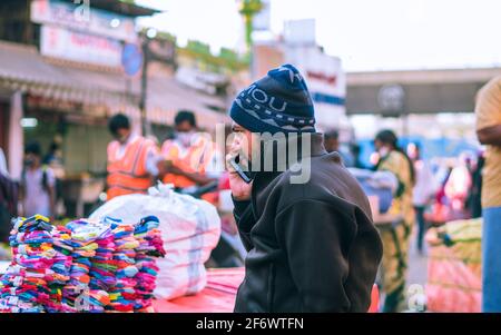 K.R.Market, Bangalore, India - February 06,2021: Street seller talking over a phone in K.R.Market Stock Photo