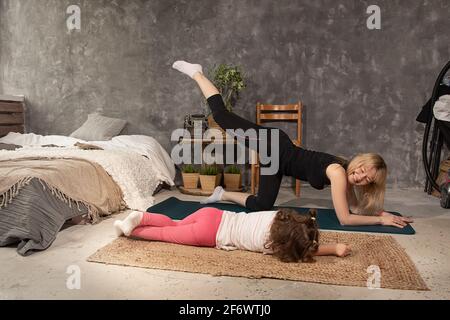 mother and little daughter practicing yoga together at home,Health, sport, leasure concept Stock Photo