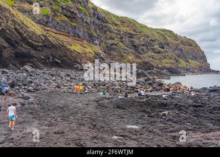 SAO MIGUEL, AUGUST 29, 2020: Natural volcanic rocks near Ponta da Ferraria, the place where hot springs mix with seawater in Sao Miguel island, Azores Stock Photo